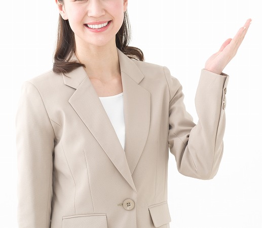 案内するベージュスーツの女性